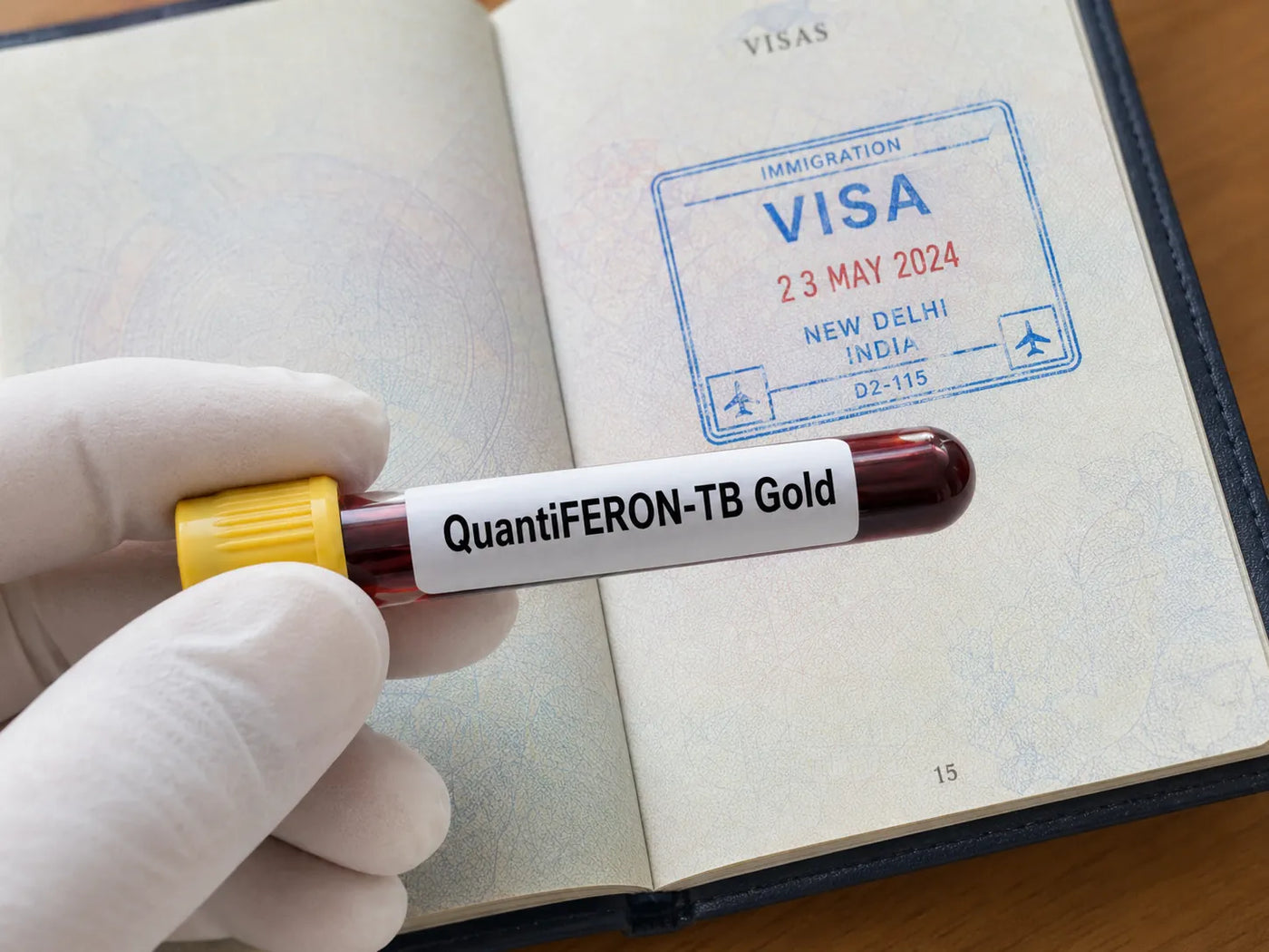 open passport with a visa inside it, and a quantiferon blood test in front