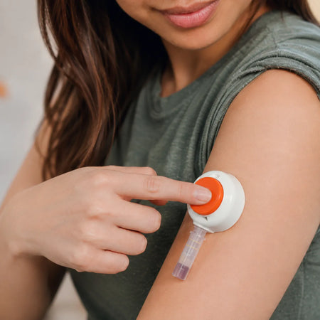 woman pressing red button on tasso device